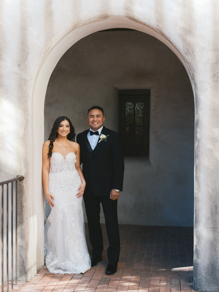 Bride and groom under an archway at Lost Mission, a Spanish-inspired Central Texas wedding venue.