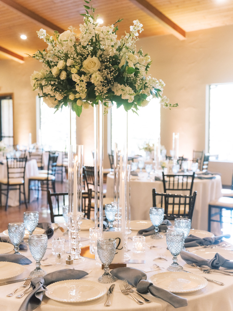 Reception table with tall floral centerpiece at The Chandelier of Gruene, styled by a local wedding planner.