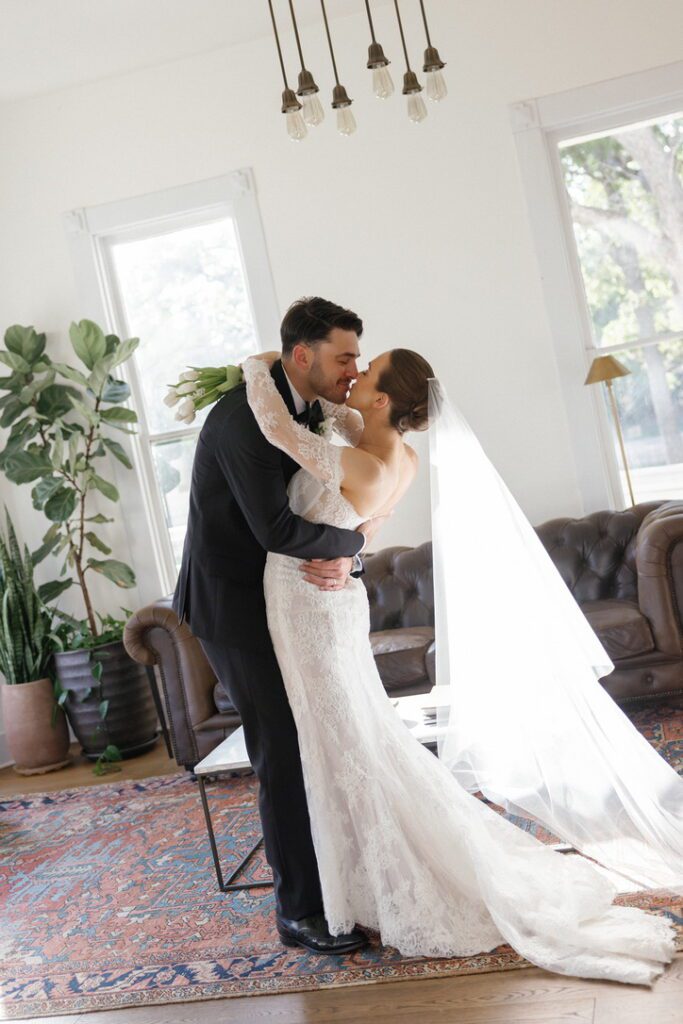 Bride and groom share a kiss inside historic house at The Grand Lady, planned by a local wedding planner.