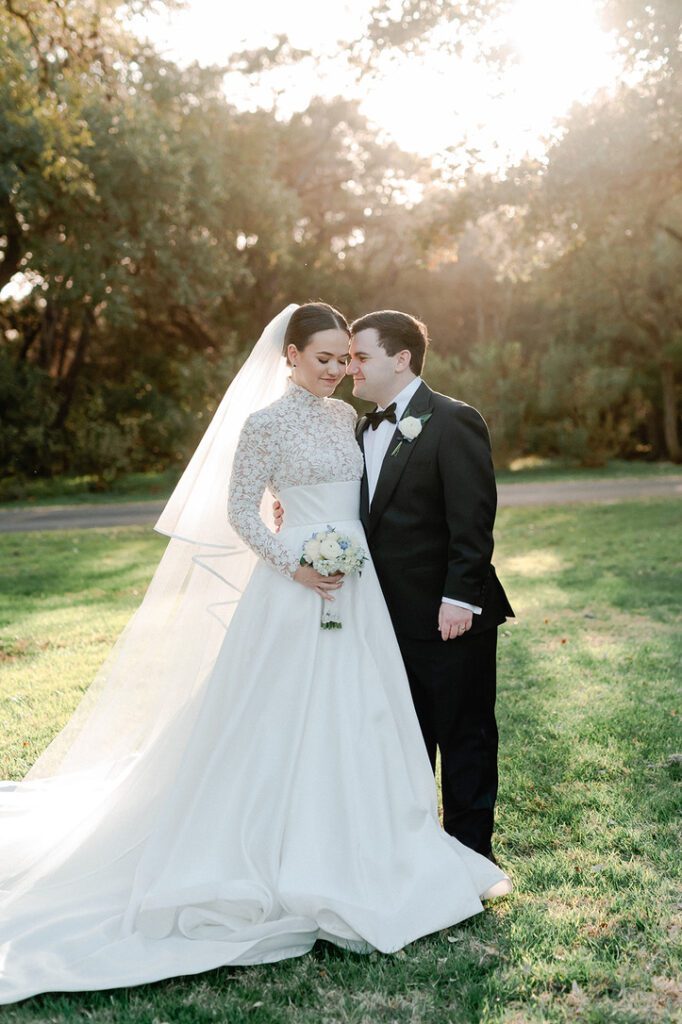 Bride and groom at sunset on the lawn of The Chandelier of Gruene, a Central Texas wedding venue.