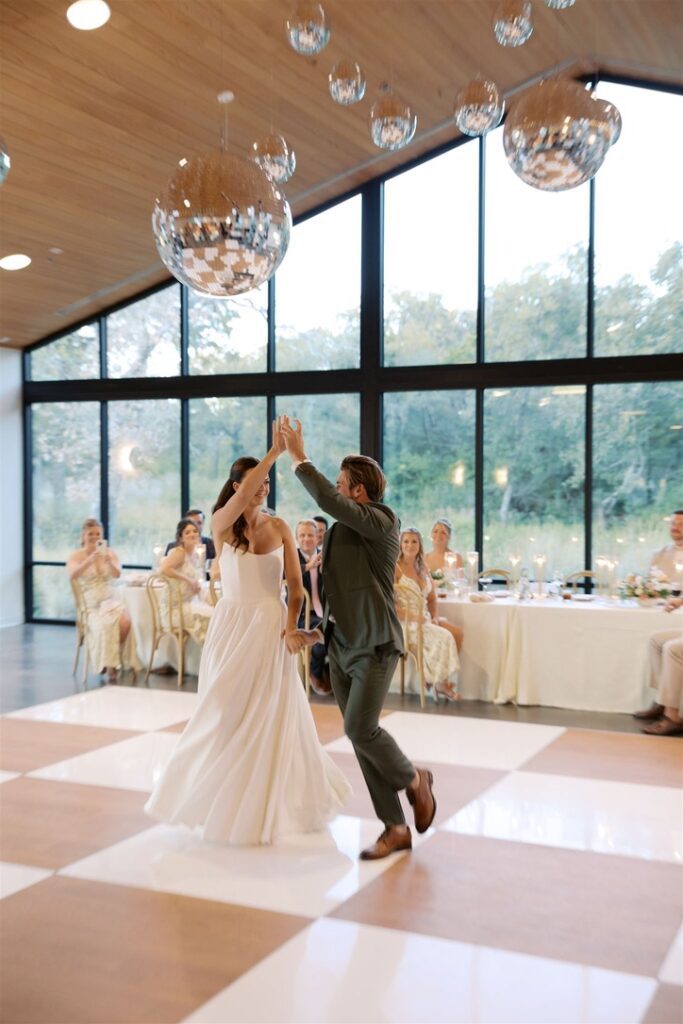 First dance in modern reception hall at The Grand Lady, a Central Texas wedding venue with floor-to-ceiling windows.