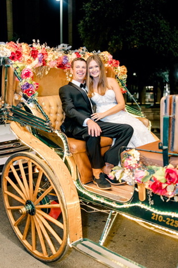 Newlyweds in a floral-decorated carriage during a Central Texas wedding, with planning by Lila Lane Events.