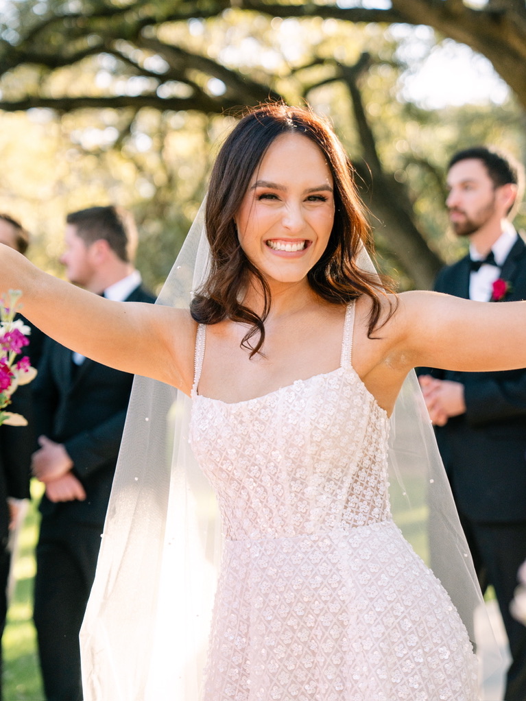 Bride smiling during outdoor wedding at The Chandelier of Gruene, a Central Texas wedding venue.
