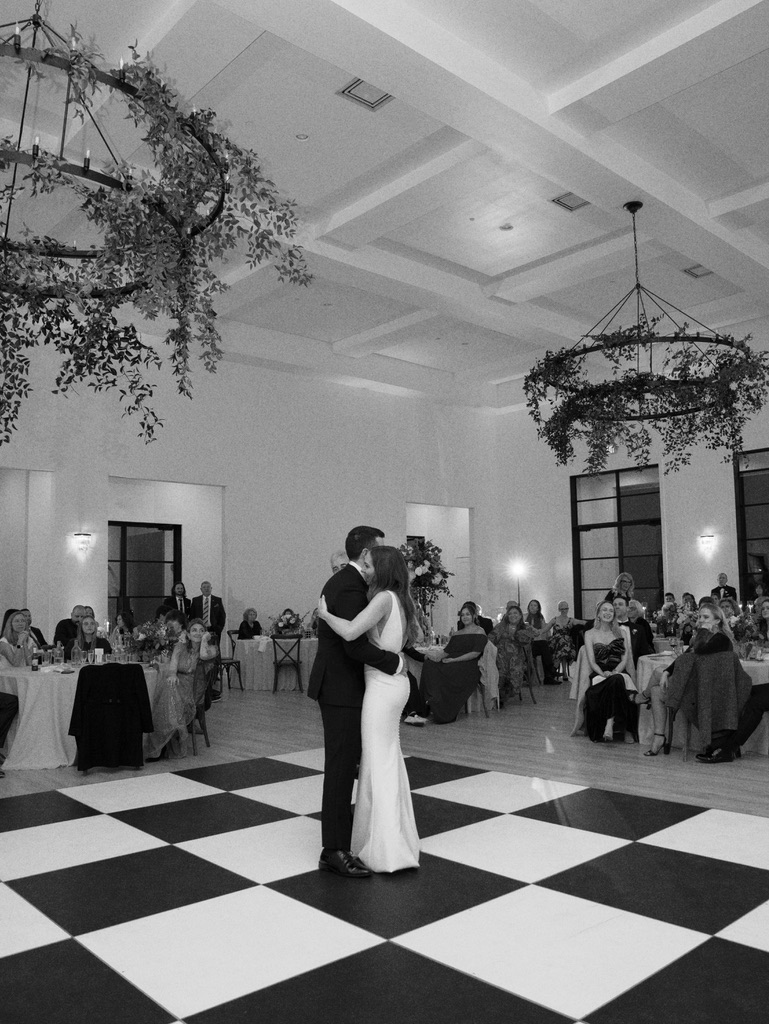Bride and groom first dance on black and white checkered floor at The Arlo, a Central Texas wedding venue.