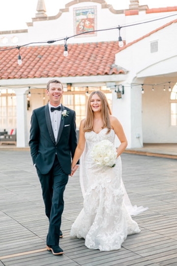 Bride and groom walking at a historic Central Texas wedding venue, with planning support for a seamless day.