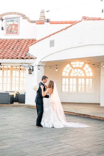 First dance on outdoor patio of a Central Texas wedding venue, designed with help from a Hill Country wedding planner.