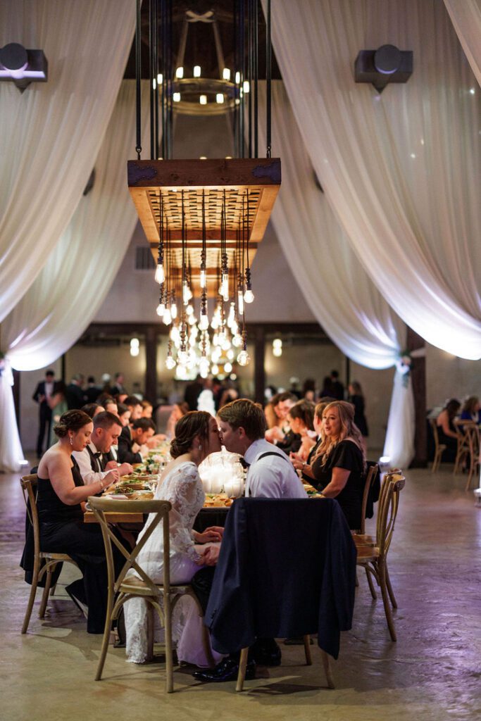 Indoor wedding reception with draped fabric and chandeliers at Lost Mission, a Central Texas wedding venue with Spanish charm.