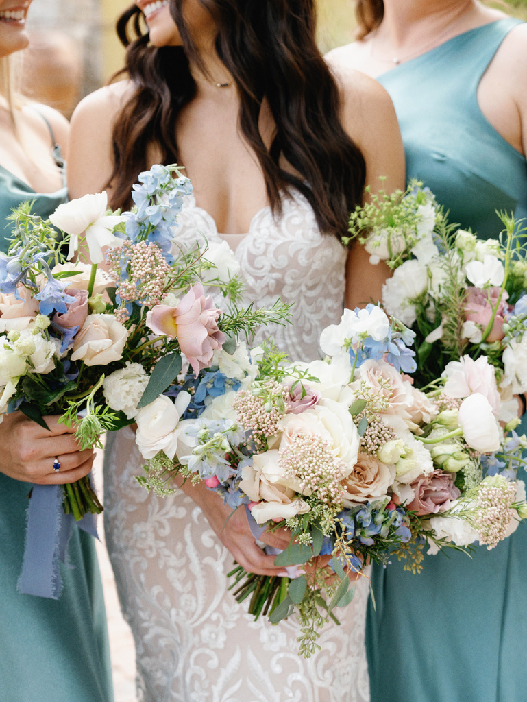 Bride holding pastel wedding bouquet with blue and blush flowers at Camp Lucy, a Central Texas wedding venue.