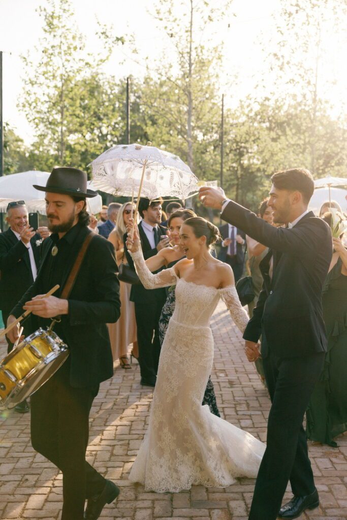 Bride and groom celebrating with second line parade at The Grand Lady, a Central Texas wedding venue with historic charm.