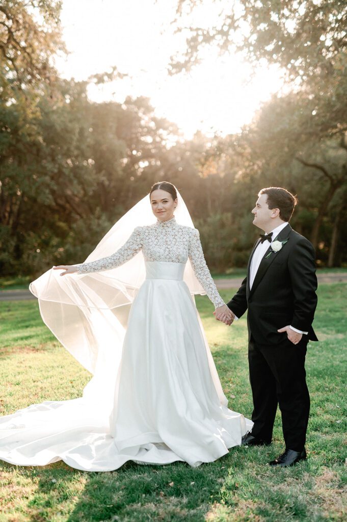 Bride and groom at sunset on lawn of The Chandelier of Gruene, a Central Texas wedding venue.
