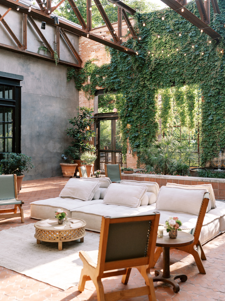 Cozy outdoor lounge area with ivy-covered walls at a Central Texas wedding venue.