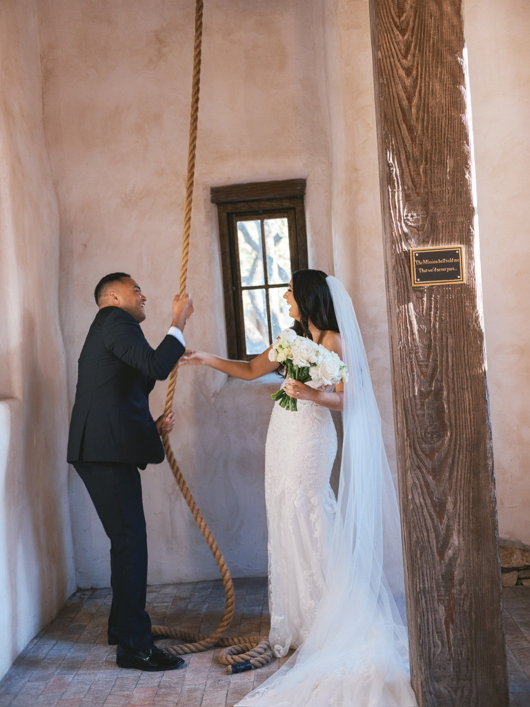 Bride and groom ringing mission bell at Lost Mission, a Central Texas wedding venue with historic charm.
