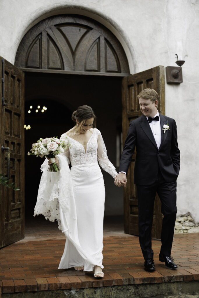Bride and groom leaving chapel doors at Lost Mission, a Central Texas wedding venue known for historic architecture.