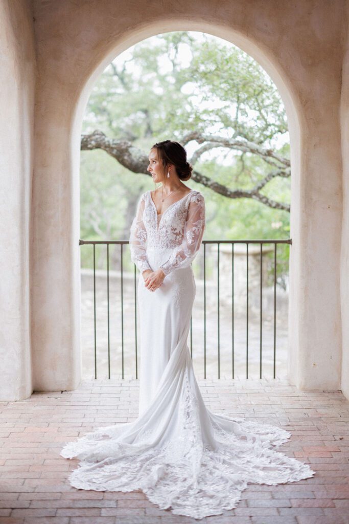 Bride posing in arched balcony at Lost Mission, a Central Texas wedding venue with old-world style.