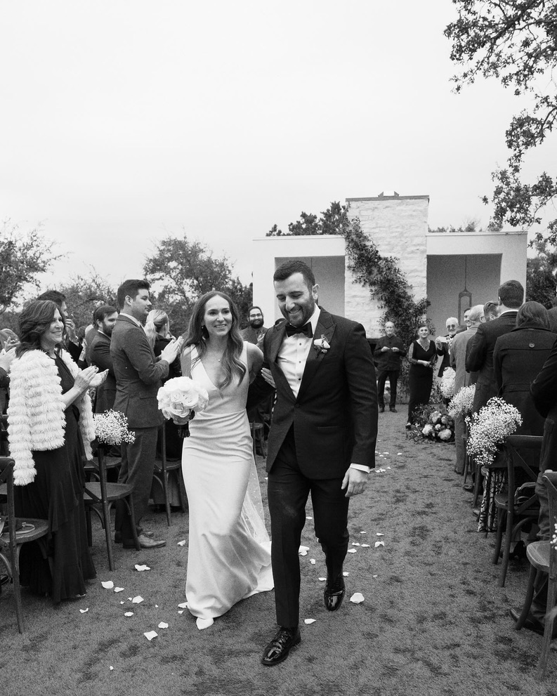 Bride and groom walking up the aisle after outdoor ceremony at a Central Texas wedding venue, planned by a local wedding planner.