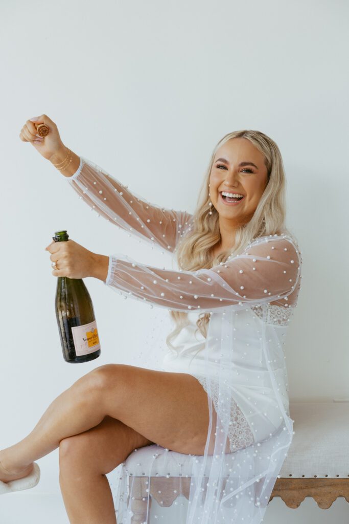 Bride celebrating with champagne during getting ready moments | Planned by San Antonio wedding planner Lila Lane Events