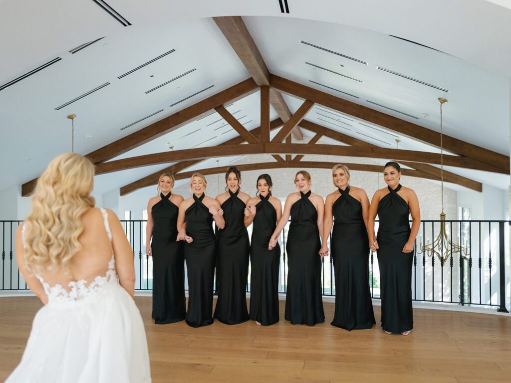 Modern bridal party in sleek black gowns inside a Hill Country wedding venue | Austin wedding planner pre-ceremony portraits