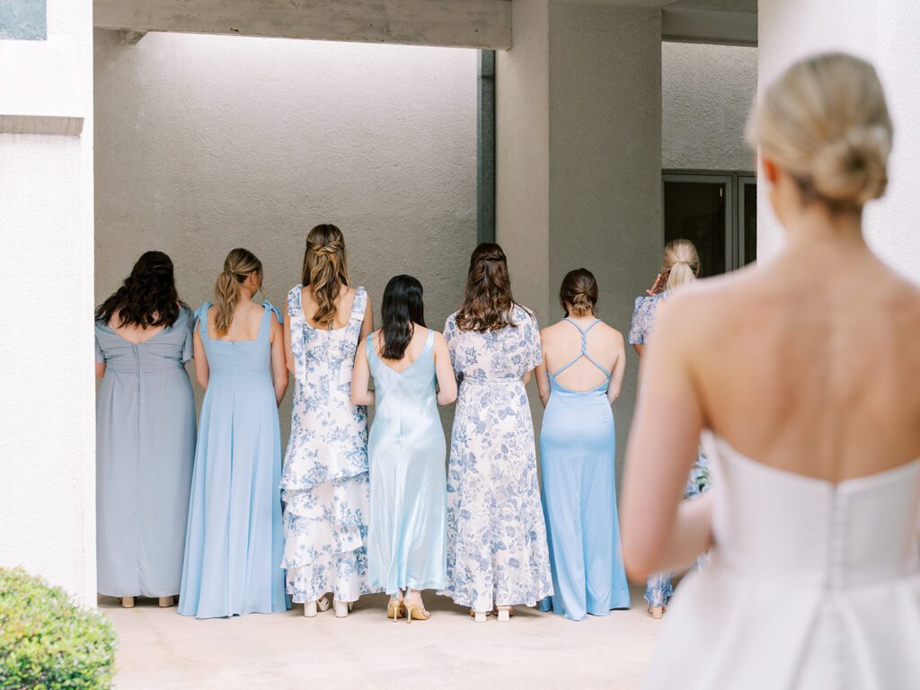 Firs look moments with bridesmaids in floral and light blue gowns | Elegant pre-ceremony moment planned by Austin wedding planner