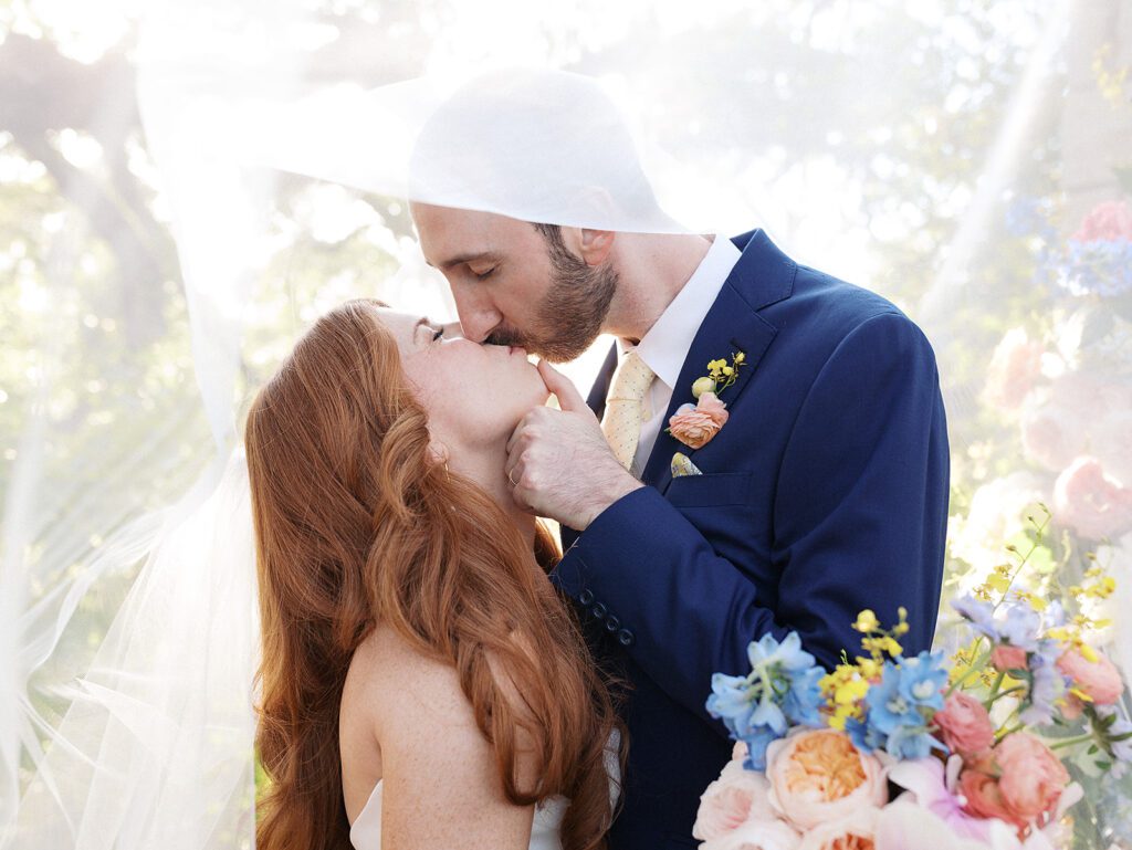 Bride and groom sharing a kiss, grateful their wedding planner helped them with what to do after getting engaged