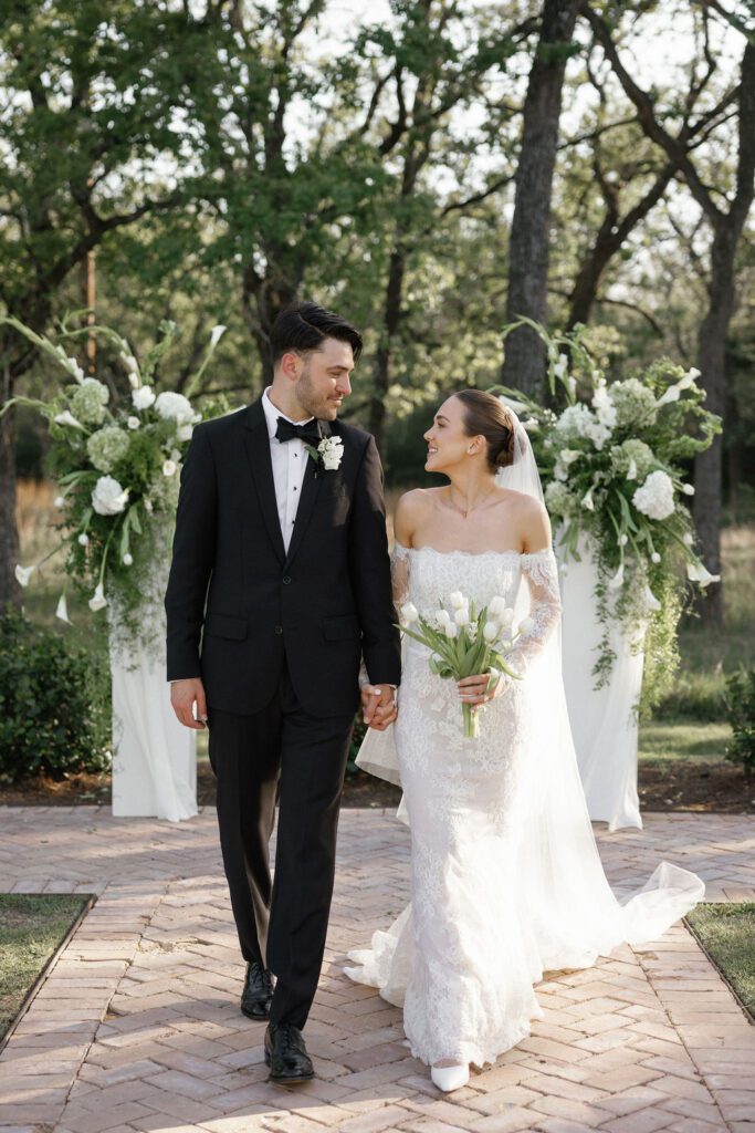 A newlywed couple walking down the aisle after being married and happy with their wedding vendor list