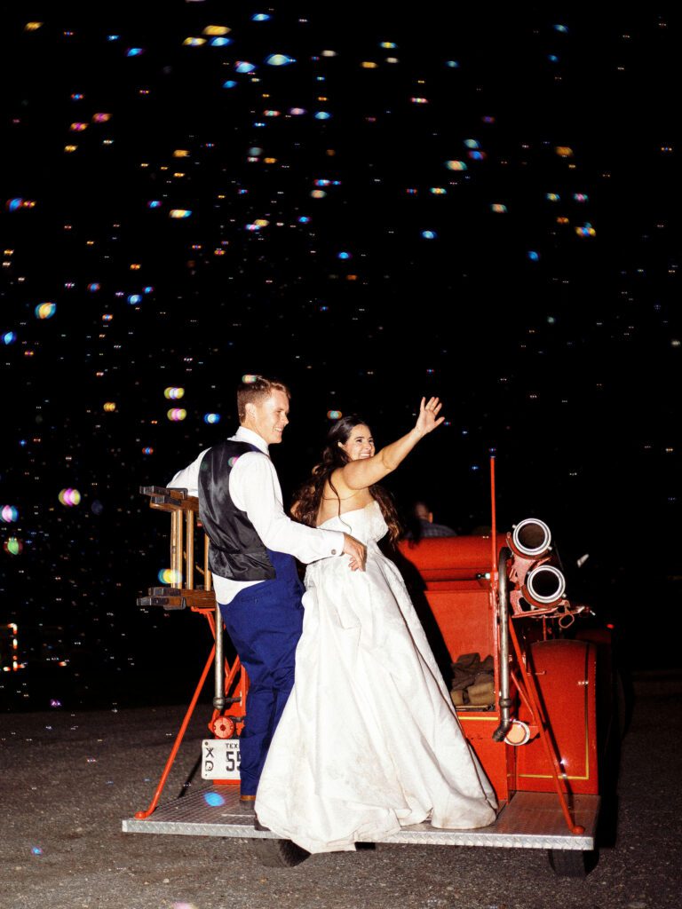An antique firetruck is quite the personalized wedding send-off for this sweet couple