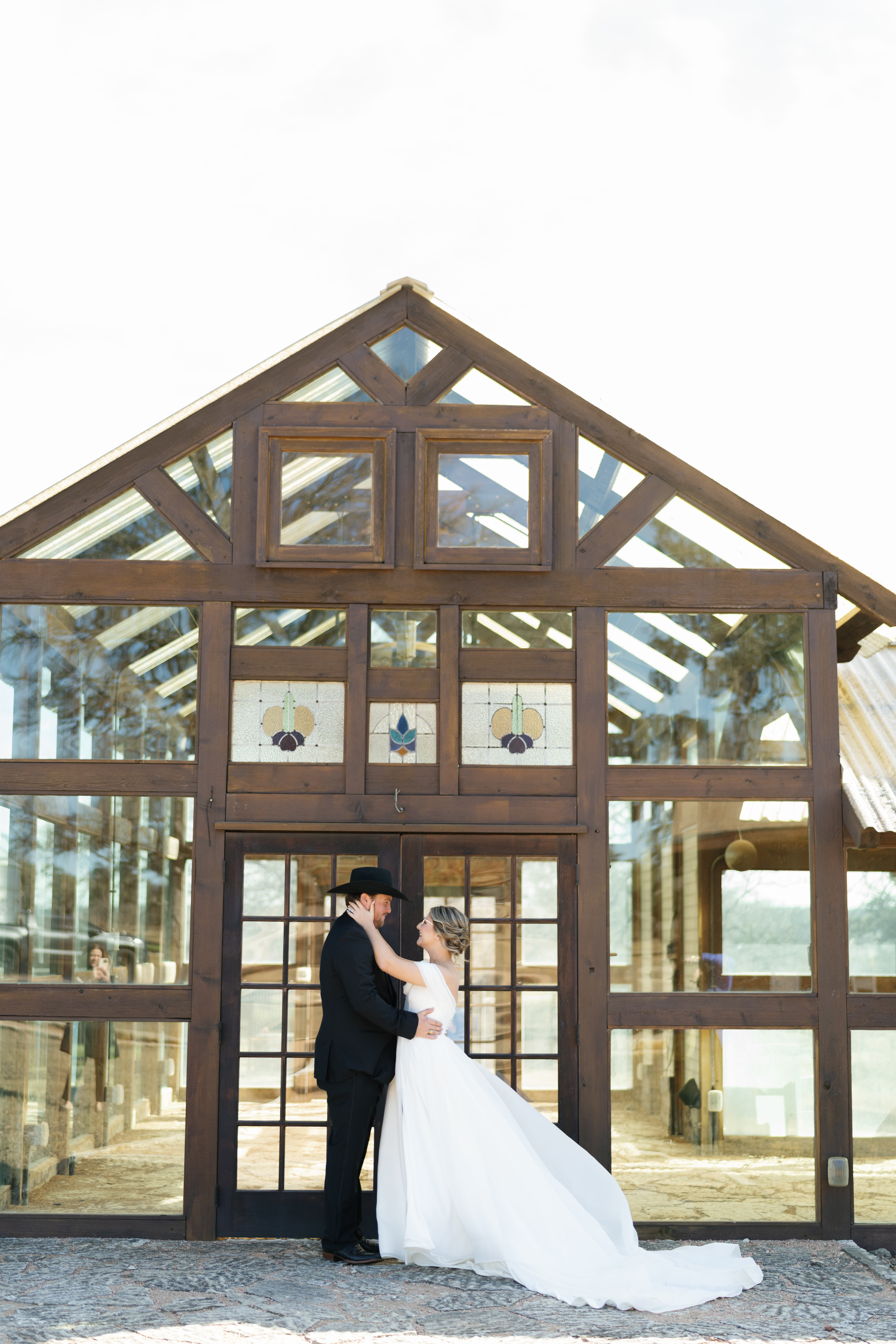 Beautiful greenhouse wedding venue in Austin with bride and groom embracing